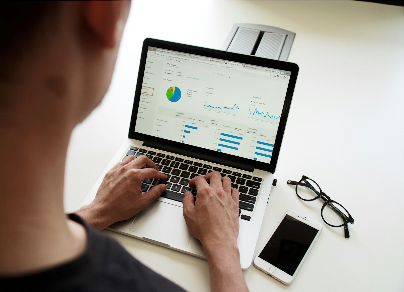 Analyst reviewing data entries and reports on a laptop screen