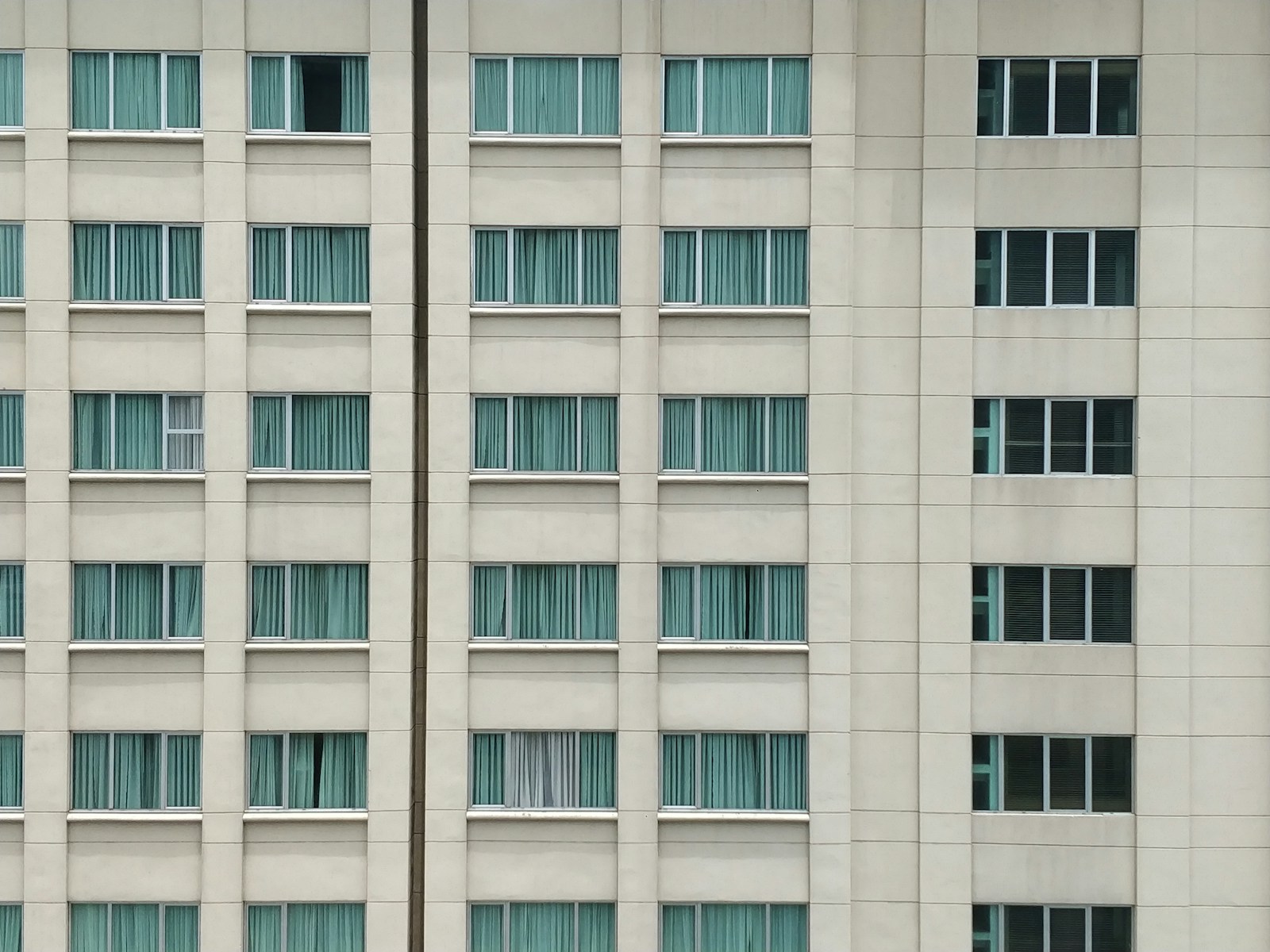 White concrete high-rise building with glass facades