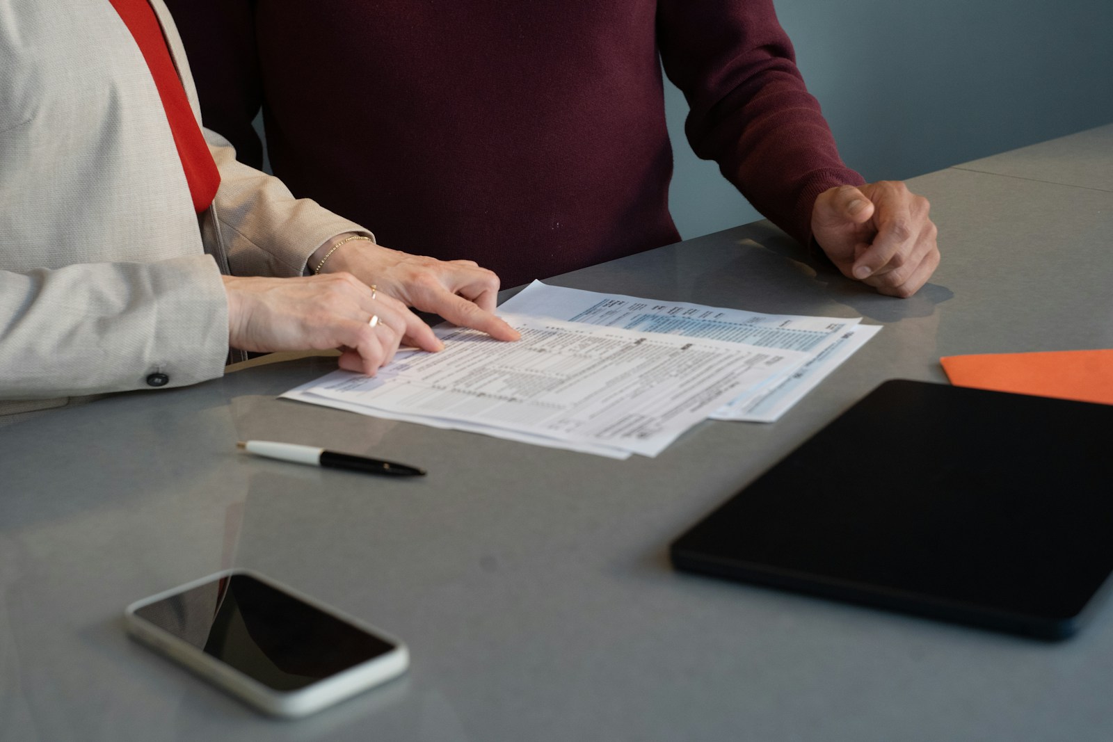 Two professionals reviewing paperwork together during a data completeness check