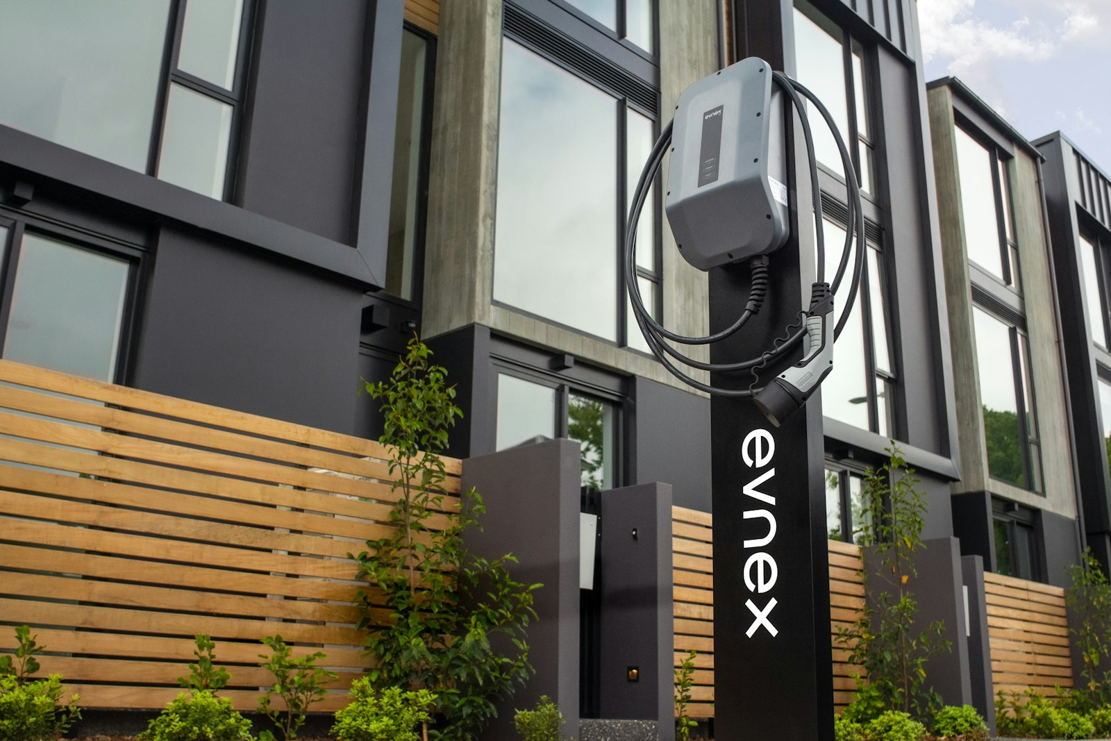 Electric vehicle charging station mounted in front of a modern building