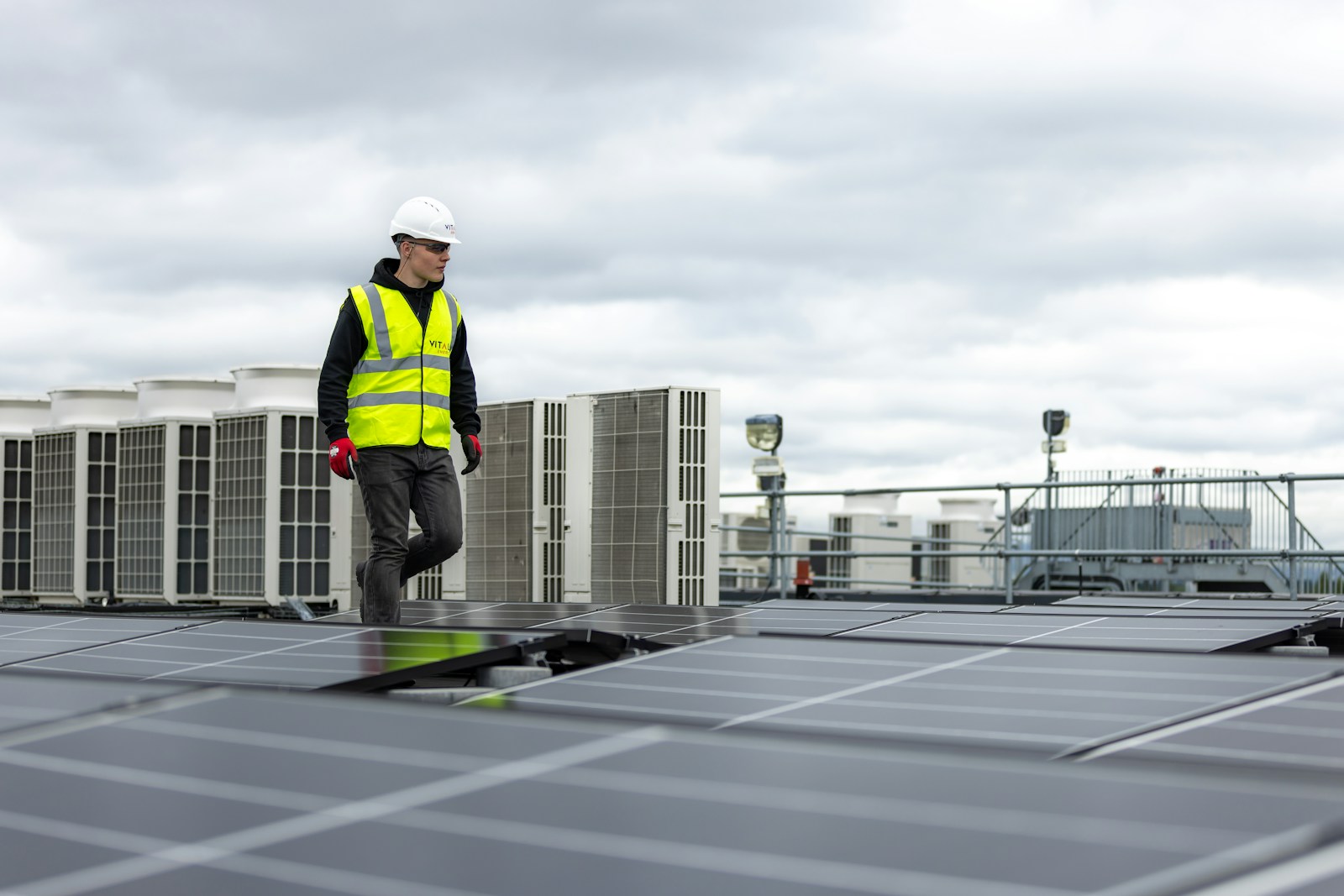 Engineer on a building roof reviewing energy equipment and installations