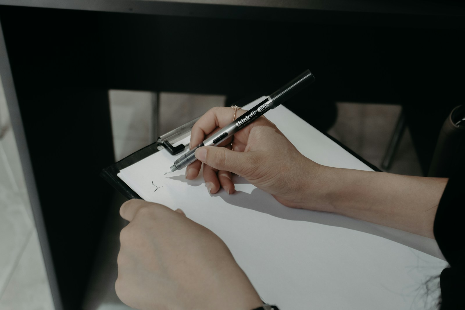 Hands writing and reviewing an improvement action plan on a clipboard