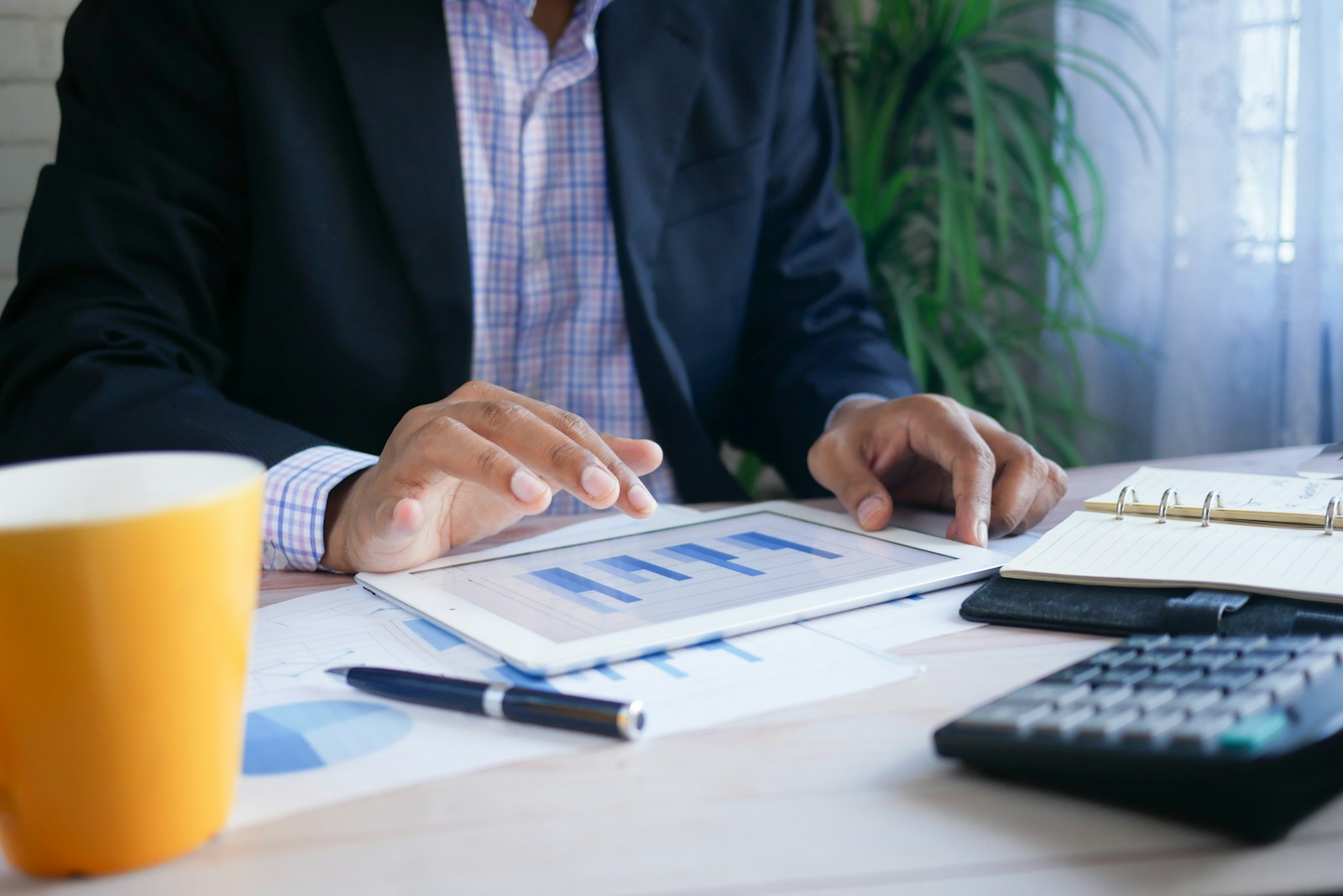 ESG Strategy and Reporting | Land Sterling Manager in a suit reviewing an annual action plan on a tablet while standing