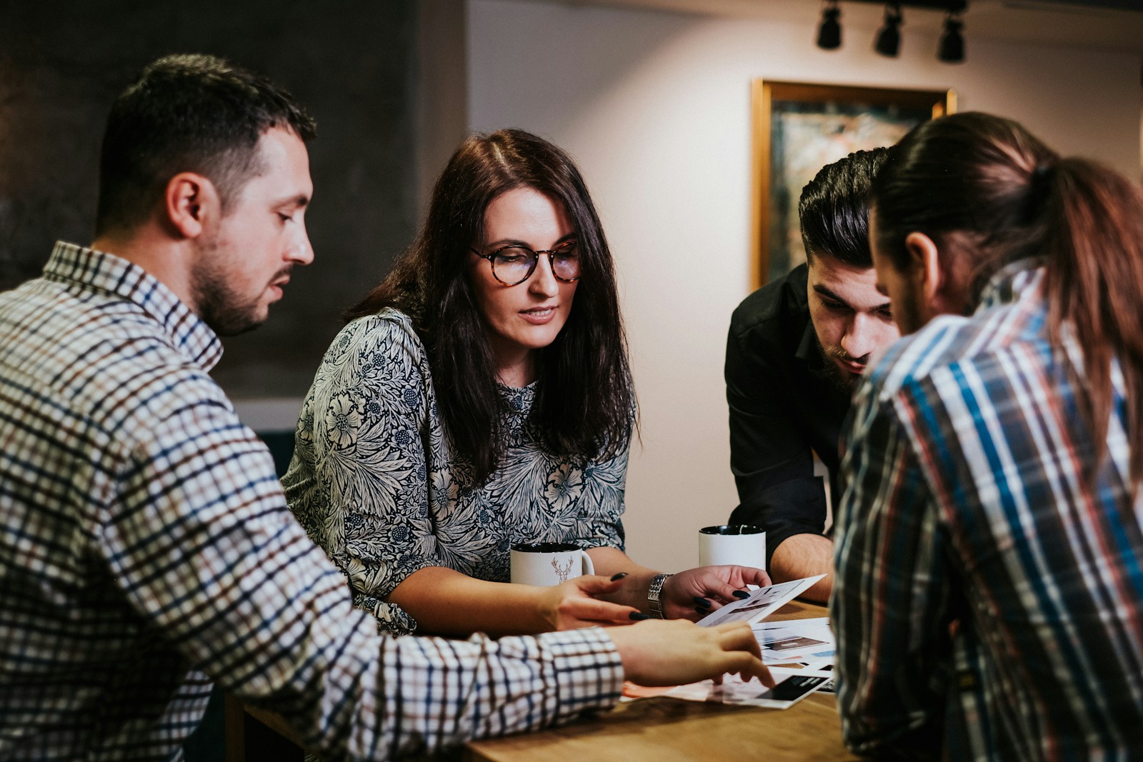 Four team members reviewing planning documents together at a wooden table